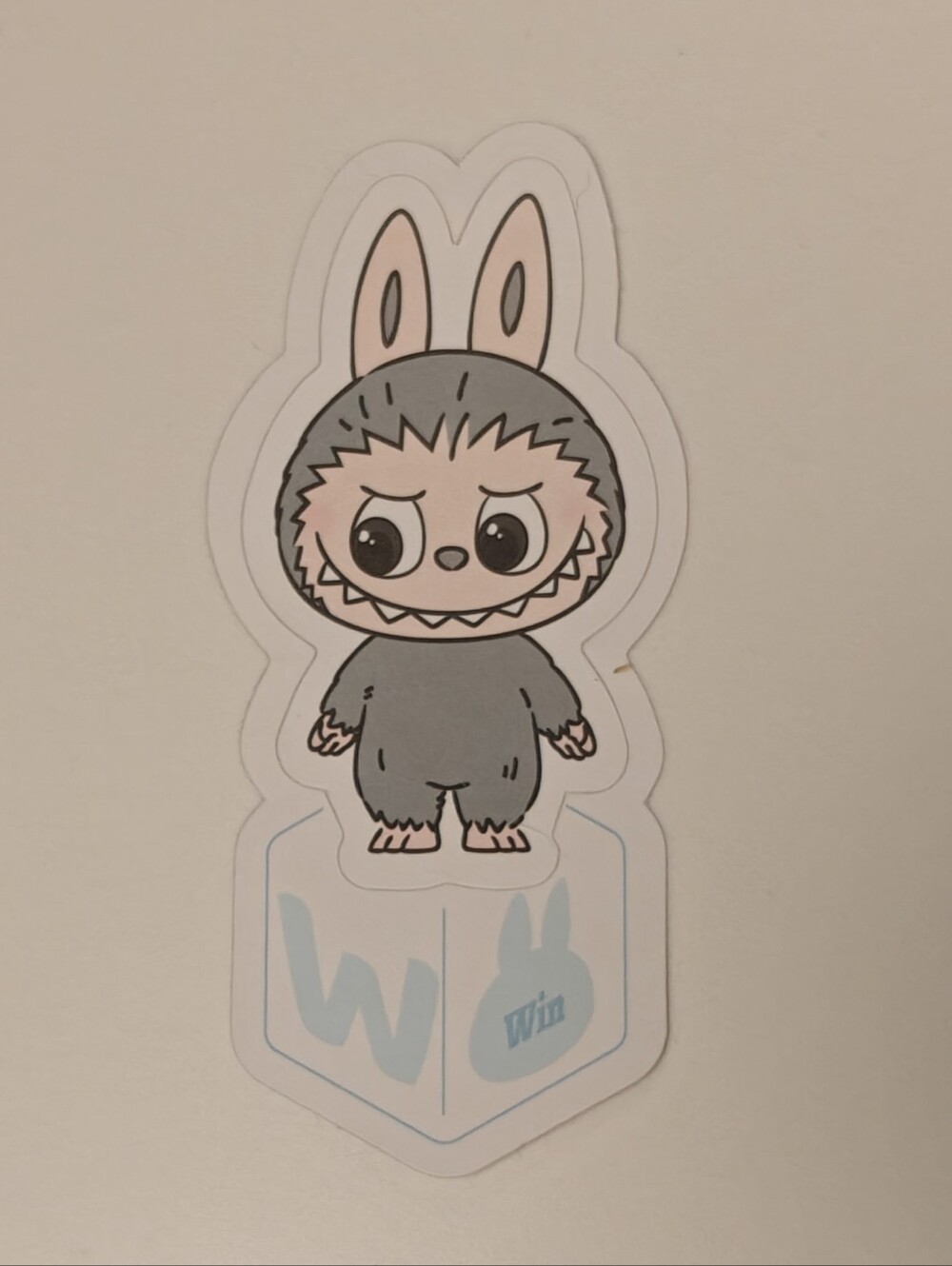 Pop Mart's Sticker Of A Grey Labubu character from "The Monsters" series